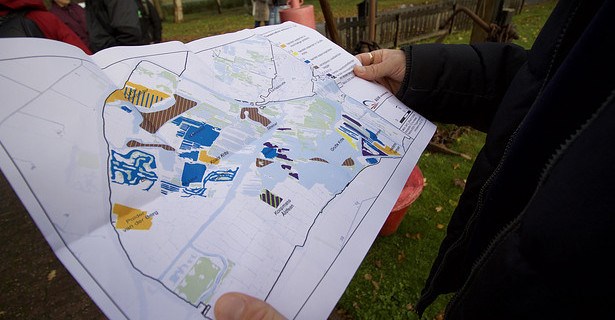 Photo of someone holding a coloured Map, showing various restoration works around Alde Feanen National Park