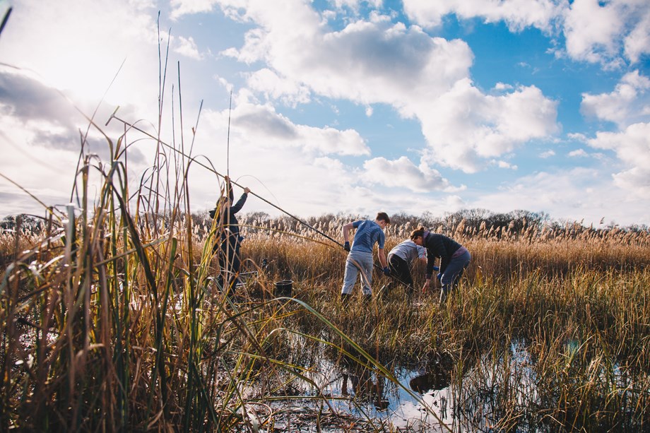 Students taking a peat core in a semi-flooded fen landscape.